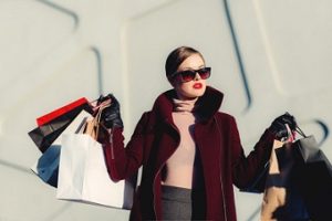 Woman in sunglasses holding shopping bags