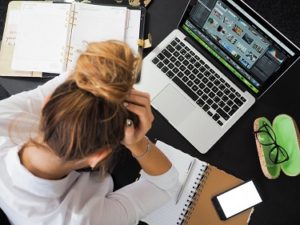 Young Woman in a white shirt stressing over her work desk