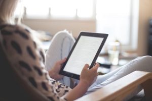 Woman in chair reading on her ipad