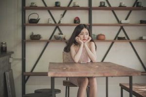 Young woman sitting at an empty table alone